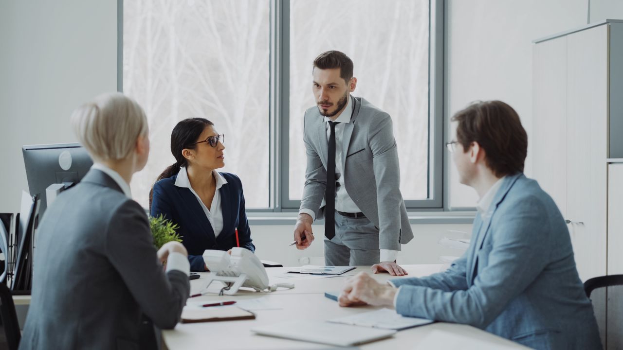 about-01 Professionals engaged in a serious business discussion in a bright office environment.
